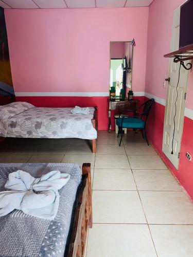 a room with two beds and a desk in it at Hospedaje Hefziba in Moyogalpa