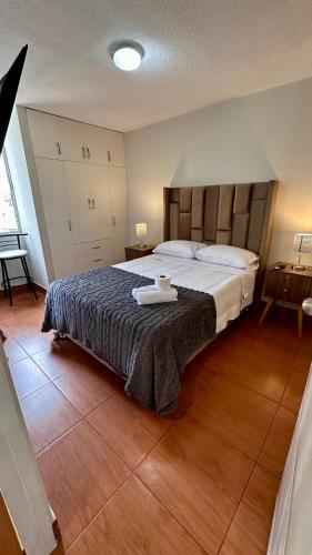 a bedroom with a large bed with a wooden floor at Hermoso Departamento Frente al Escuela de Oficiales de La policia in Lima