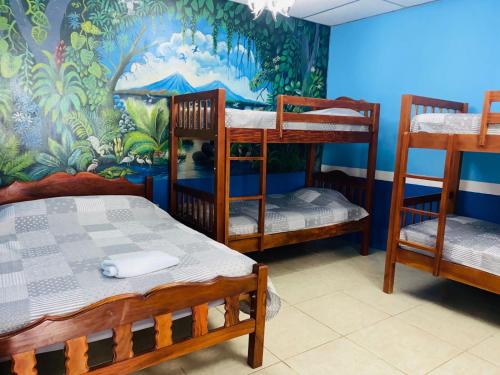 a room with three bunk beds and a mural at Hospedaje Hefziba in Moyogalpa