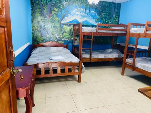 a room with three bunk beds and a mural at Hospedaje Hefziba in Moyogalpa