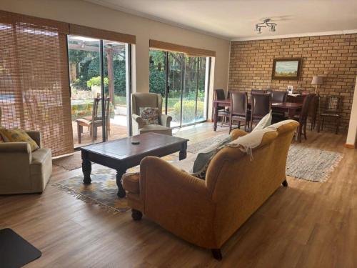 een woonkamer met een bank en een tafel bij Cherry Lane Constantia in Kaapstad