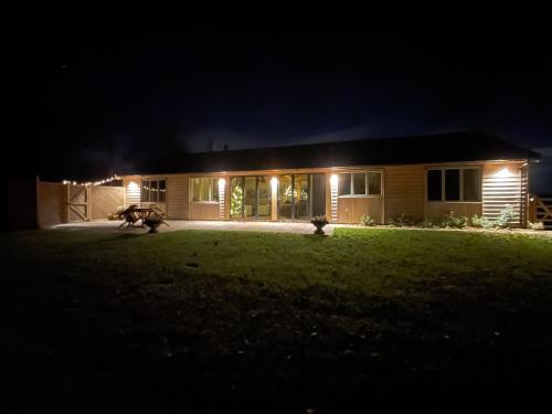a house at night with a dog in the yard at Windover Barn in Slinfold
