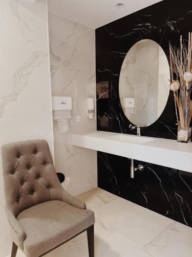 a bathroom with a chair and a mirror at Doade in Hio