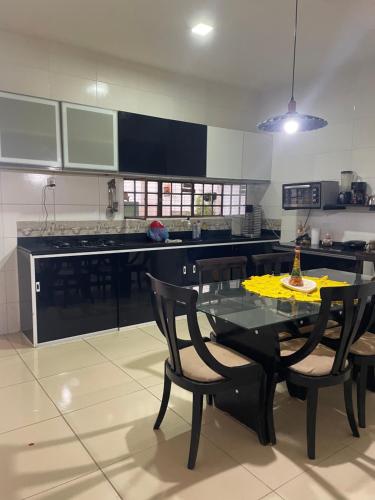 a kitchen with a black table and chairs in it at Casa Bela Vista in Pão de Açúcar