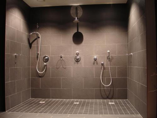 a bathroom with a walk in shower with shower heads at Appartement Haus Sonne in Zell am See