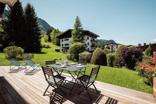une table et des chaises sur une terrasse en bois dans l'établissement Chamois Blanc - Ideal for families, à Megève