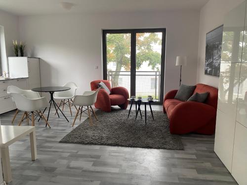 a living room with red furniture and a table and chairs at Apartament Zoom 42 in Bydgoszcz