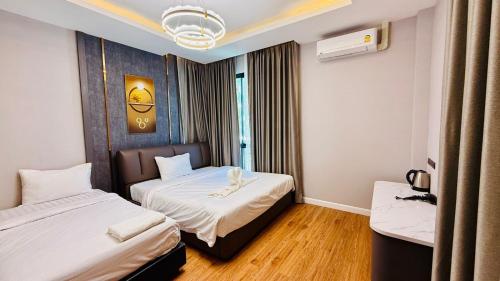 a hotel room with two beds and a window at Auqa Pool Villa by DRH in Ban Bung