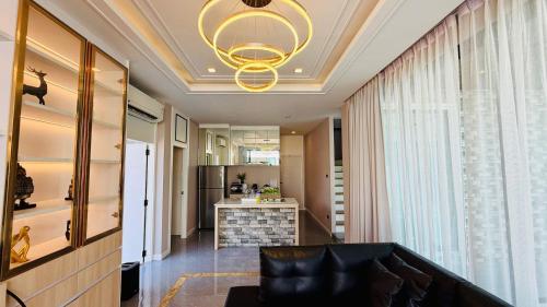 a living room with a couch and a chandelier at Auqa Pool Villa by DRH in Ban Bung