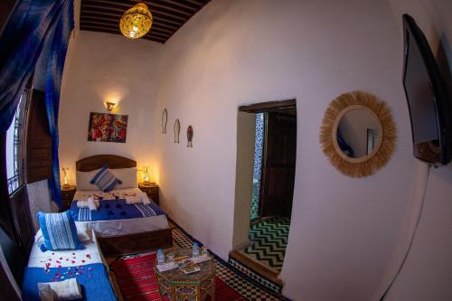 a hotel room with two beds and a mirror at Riad LalaMoune in Fez