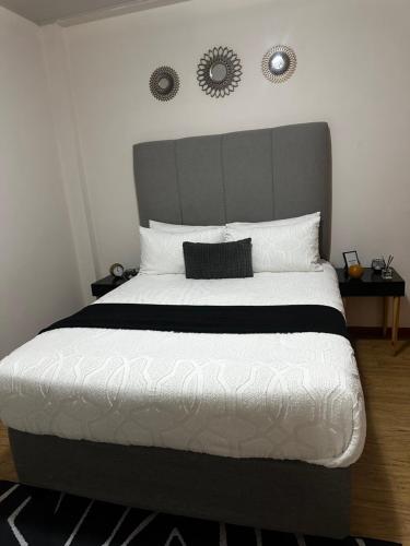 ハボローネにあるRibbon 210's Two bedroom apartmentのベッドルーム1室(大型ベッド1台、グレーのヘッドボード付)
