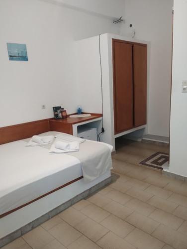 a bedroom with a bed and a desk and a cabinet at Oleander's Garden Traditional Cretan Cottage in Ferma