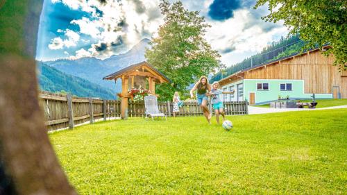 two girls playing with a soccer ball in a yard at Huberbauer in Johnsbach