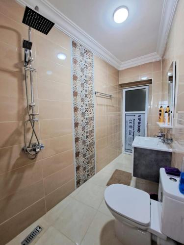 a bathroom with a toilet and a sink and a shower at Diafa Stay in Tangier