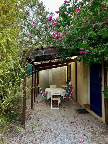un patio con mesa y sillas bajo una pérgola en Charmant bas de villa avec jardin, en La Ciotat