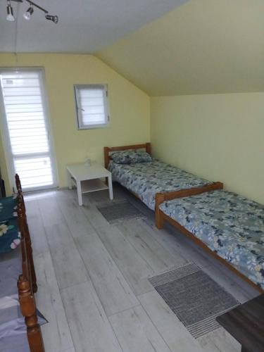 a bedroom with two beds and a table at green house at silver lake in Ostrovo