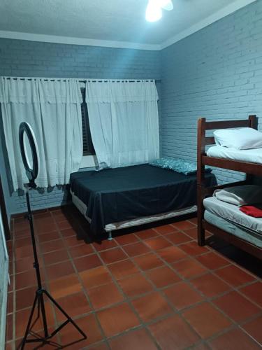 a bedroom with two bunk beds and a camera at Pousada do Bill in Peruíbe