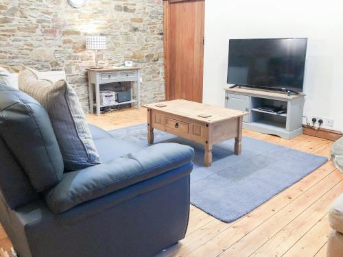 a living room with a couch and a coffee table at The Old Cow Shed in Barlow