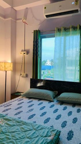 a bedroom with a bed with a large window at Windchime9 in Guwahati