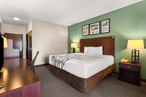 a hotel room with a bed and a desk at Sleep Inn & Suites Bush Intercontinental - IAH East in Humble