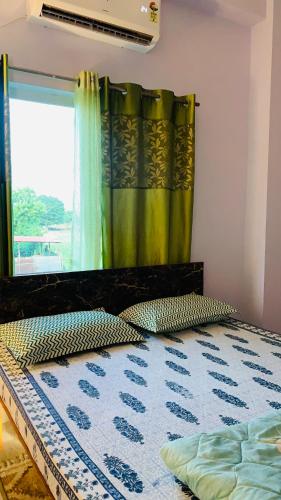 a bedroom with a bed with a window and a curtain at Windchime9 in Guwahati