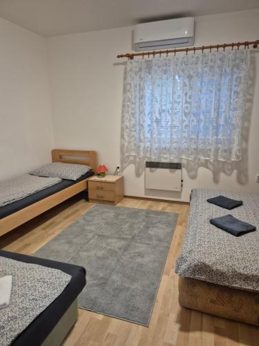 a room with two beds and a window at Apartmany-Anna in Podhájska