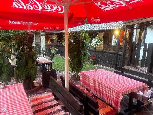 a table with a red umbrella on a patio at Apartment Mila in Plitvička Jezera