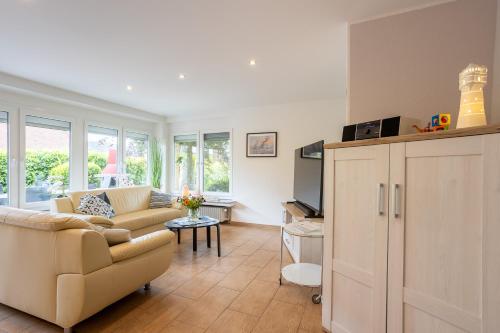 a living room with a couch and a tv at Ferienhaus Robbenglück - Ihr Rückzugsort an der Nordsee für Familien, Gruppen und Erholungssuchende in Butjadingen OT Tossens