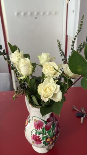 a white vase with flowers in it on a table at Red Flat Paris in Paris