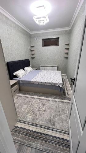 Un dormitorio pequeño con una cama en una habitación. en Квартира APPETIT, en Andiján