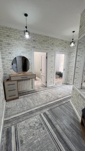 a living room with a tv on a brick wall at Квартира APPETIT in Andijan