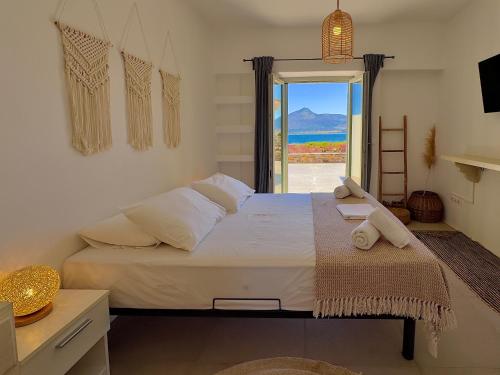 a bedroom with a bed with a view of the ocean at Farous seaside sunset villa in Agios Georgios
