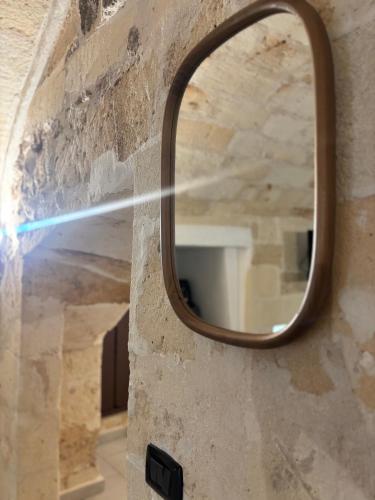 a mirror on the side of a stone wall at la nicchia, relax room & salento stay in Manduria
