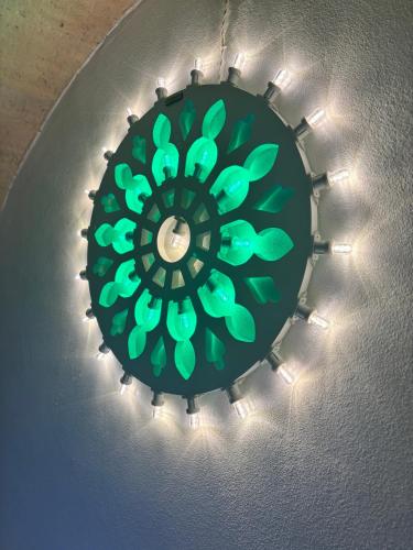 a green chandelier with lights on a ceiling at la nicchia, relax room & salento stay in Manduria
