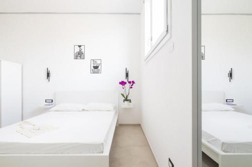 a room with two beds and a mirror at EnSe Affittacamere in Tortolì