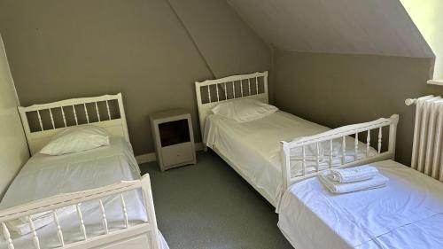 Veauville-les-BaonsにあるSalle Ancienne Ferme du Chateauの部屋にベッドが3つある部屋