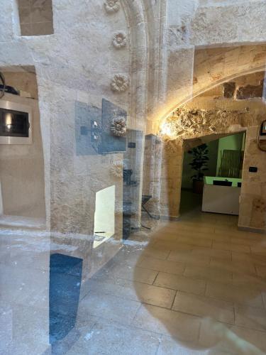 a room with a stone wall and a hallway at la nicchia, relax room & salento stay in Manduria