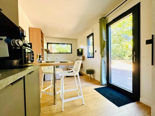 a kitchen with a counter and a table with chairs at Domaine du Mafay - LODGE BROCÉLIANDE in Bourg-des-Comptes