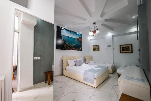 a hotel room with two beds and a table at Andy Apartments in Sarandë