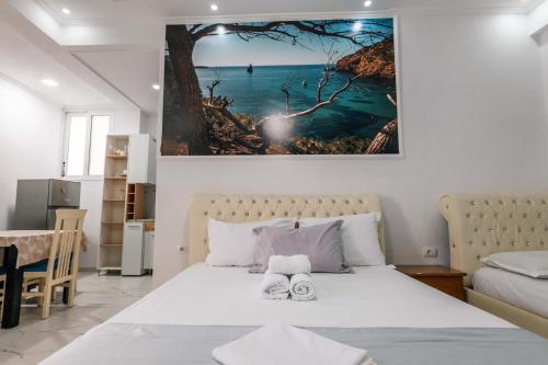 a bedroom with a bed with two towels on it at Andy Apartments in Sarandë