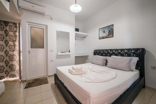 a bedroom with a large bed with a black headboard at Andy Apartments in Sarandë