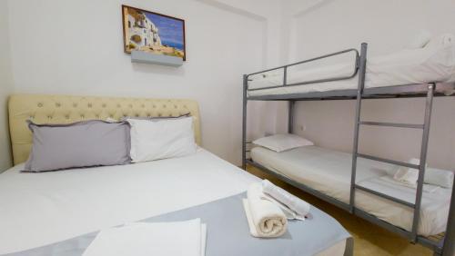 a bedroom with two bunk beds and a table at Andy Apartments in Sarandë