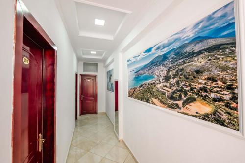 a hallway with two paintings on the walls at Andy Apartments in Sarandë