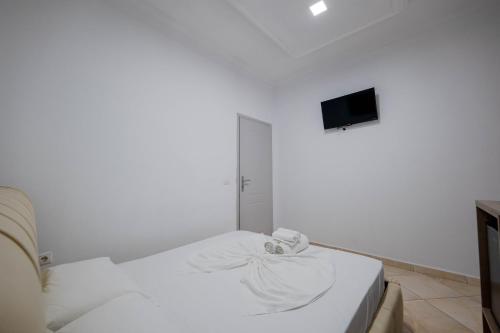 a white room with a bed and a tv at Andy Apartments in Sarandë