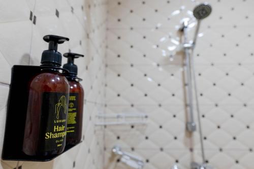 a bottle of hair shampoo is hanging in a bathroom at Andy Apartments in Sarandë