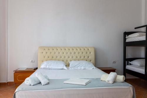 a bedroom with a bed with two towels on it at Andy Apartments in Sarandë