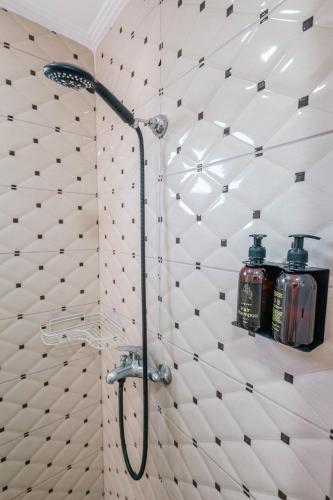 a bathroom with a shower with two bottles on a wall at Andy Apartments in Sarandë