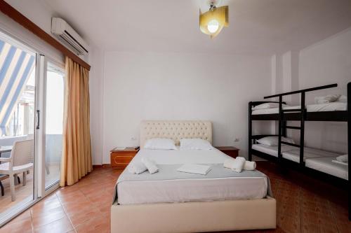 a bedroom with two bunk beds and a balcony at Andy Apartments in Sarandë