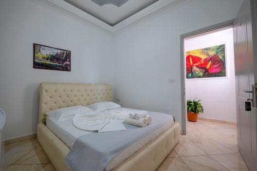 a white bedroom with a bed in a room at Andy Apartments in Sarandë