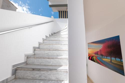 a staircase in a house with a painting on the wall at Andy Apartments in Sarandë